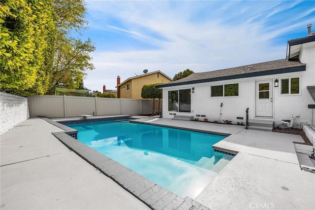 view of swimming pool with a diving board and a patio