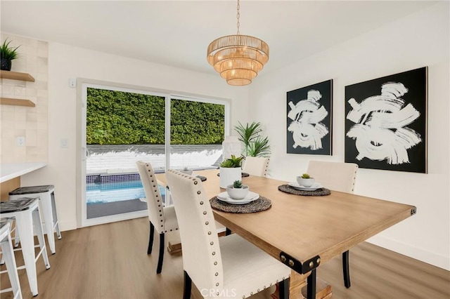 dining space featuring hardwood / wood-style floors and a chandelier