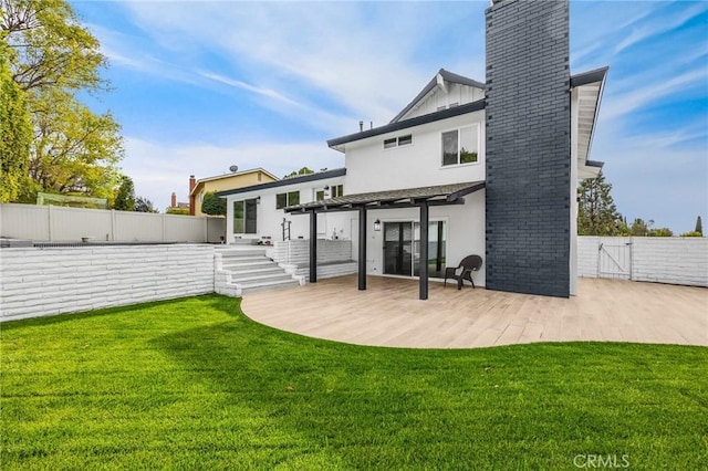 back of house featuring a lawn, a pergola, and a patio