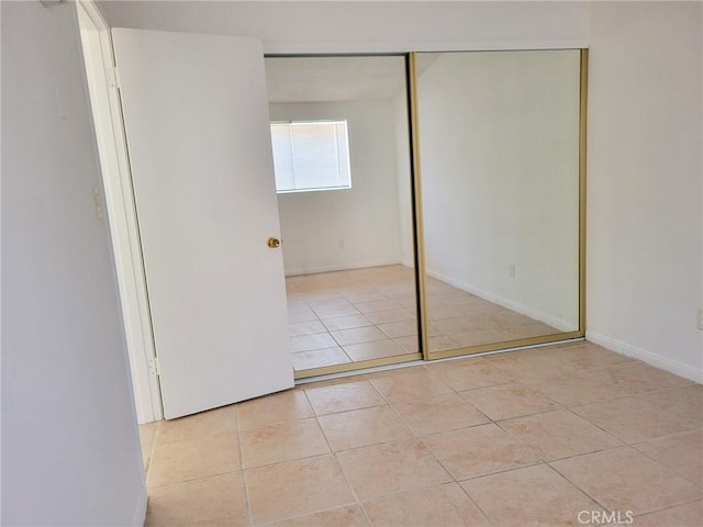 unfurnished bedroom featuring a closet and light tile patterned flooring