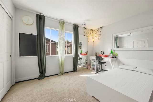 bedroom featuring light colored carpet and a closet