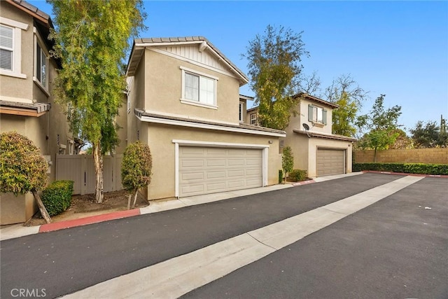 view of front of home with stucco siding and fence