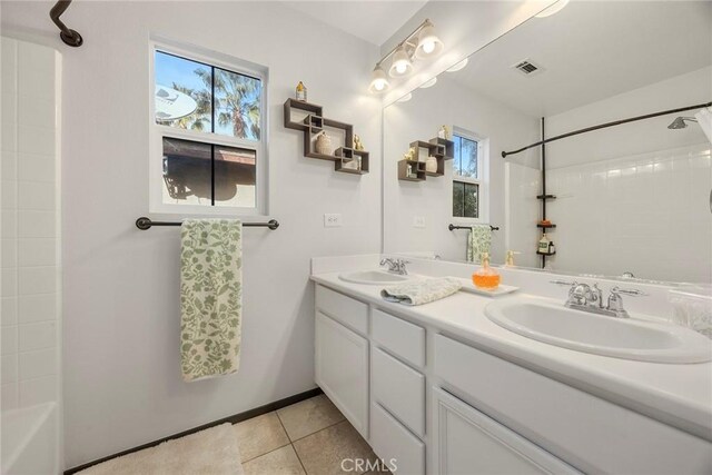 bathroom with tile patterned flooring, vanity, plenty of natural light, and shower / bathing tub combination