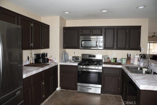 kitchen with stainless steel appliances, dark brown cabinetry, and sink