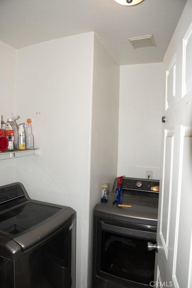 clothes washing area with washer and clothes dryer