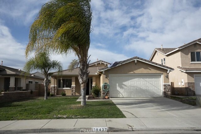 view of front of home with a front yard and a garage