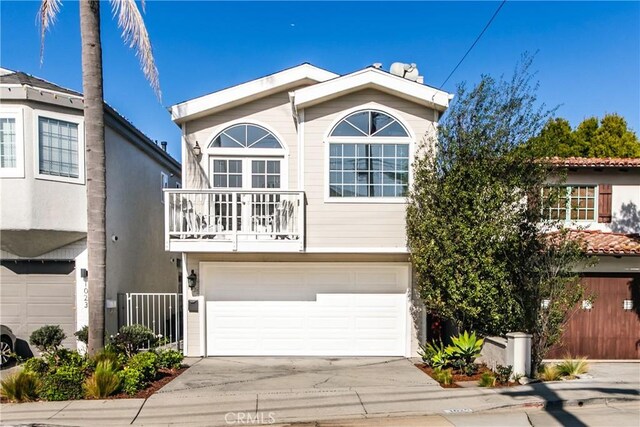 view of front of property featuring a balcony and a garage