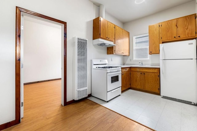 kitchen featuring white appliances, light hardwood / wood-style flooring, and sink