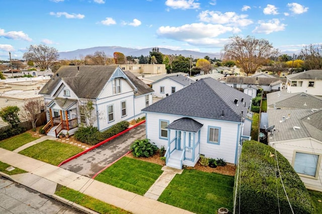 view of front of home with a front yard and a mountain view