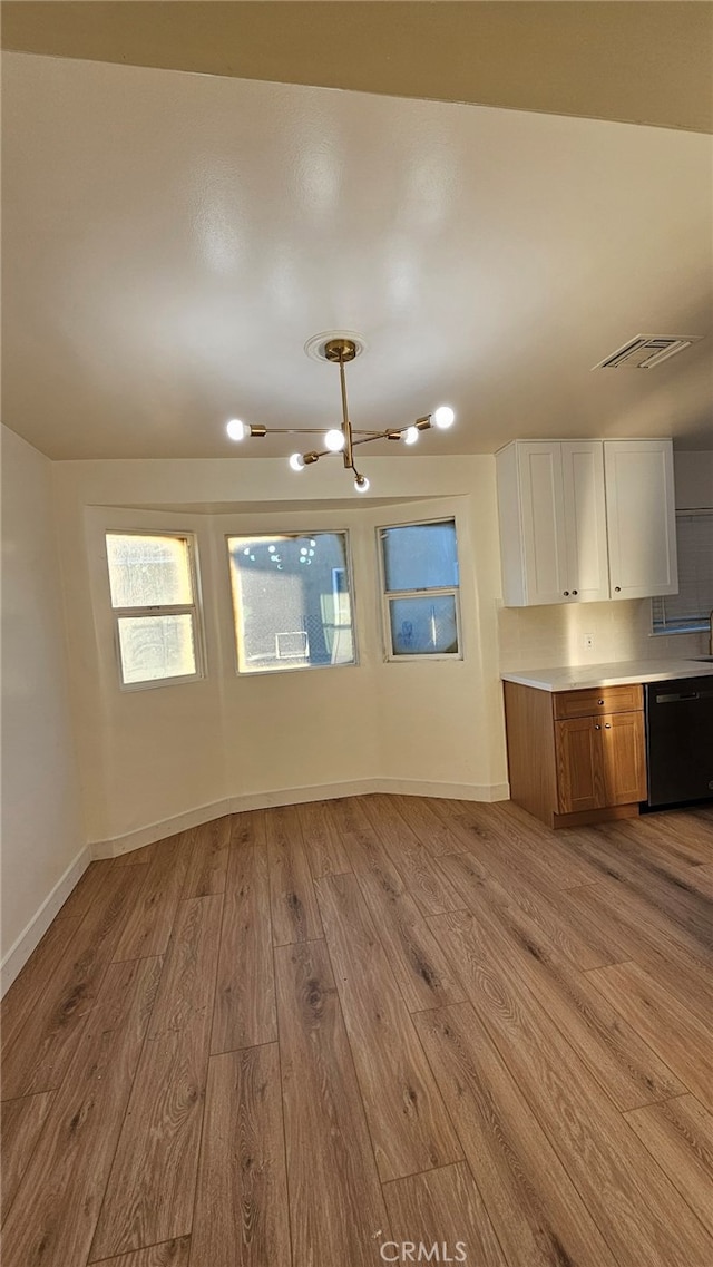 kitchen with black dishwasher, white cabinetry, and light hardwood / wood-style flooring