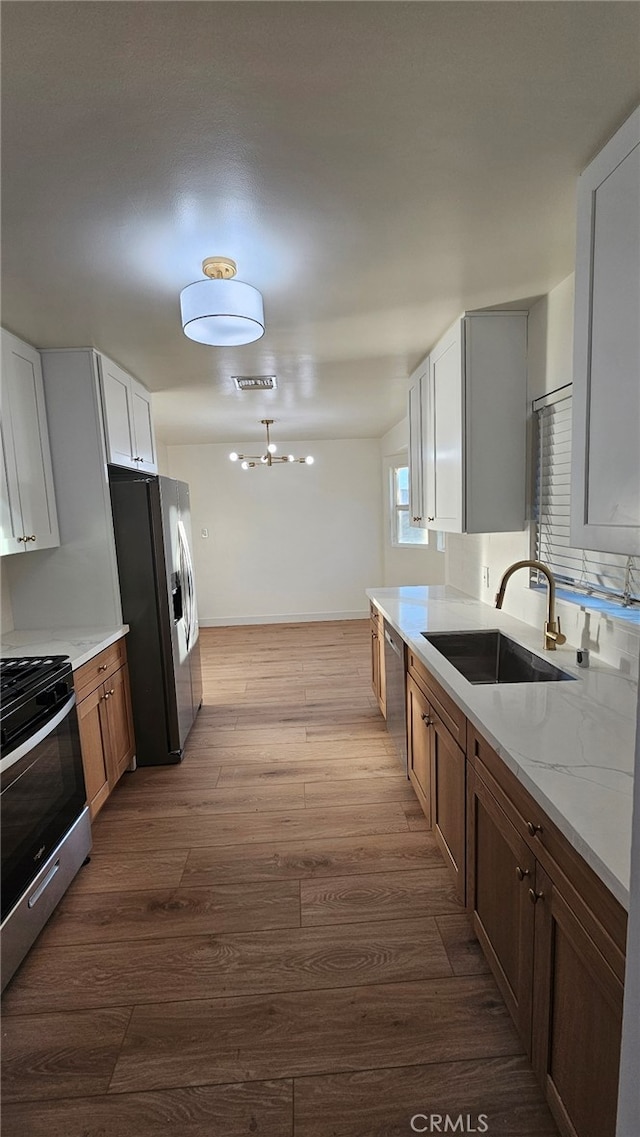 kitchen featuring light stone countertops, white cabinets, stainless steel appliances, sink, and dark hardwood / wood-style floors