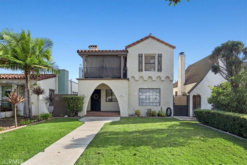 mediterranean / spanish-style home featuring a balcony and a front yard