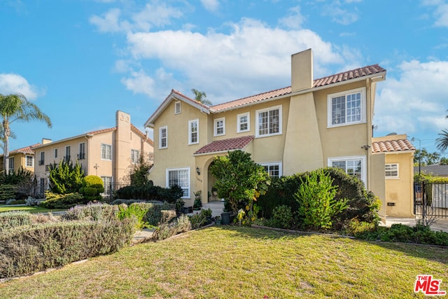 mediterranean / spanish home with a front yard