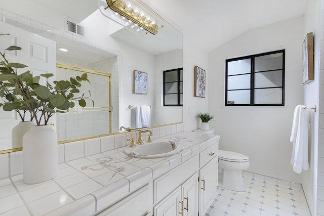 bathroom with a shower with shower door, lofted ceiling, vanity, and toilet