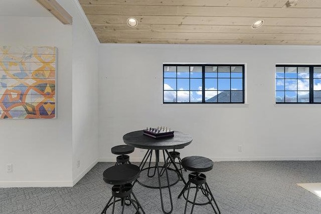 carpeted dining space featuring beamed ceiling and wooden ceiling