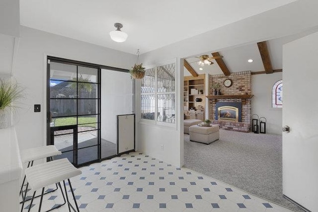 living room with light carpet, a fireplace, ceiling fan, and beamed ceiling