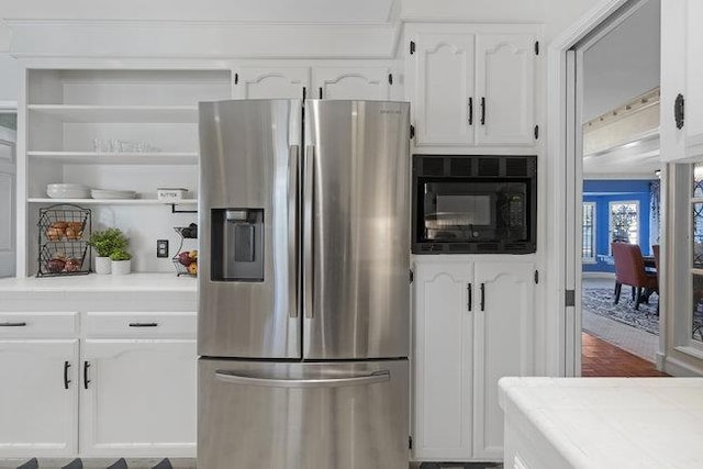 kitchen featuring white cabinetry, stainless steel fridge with ice dispenser, black microwave, and tile countertops