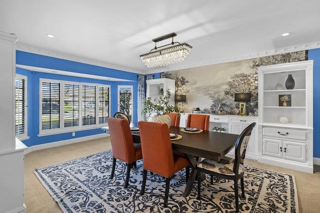 dining space featuring a notable chandelier, ornamental molding, and light carpet