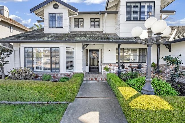 view of front of property featuring covered porch and a front lawn