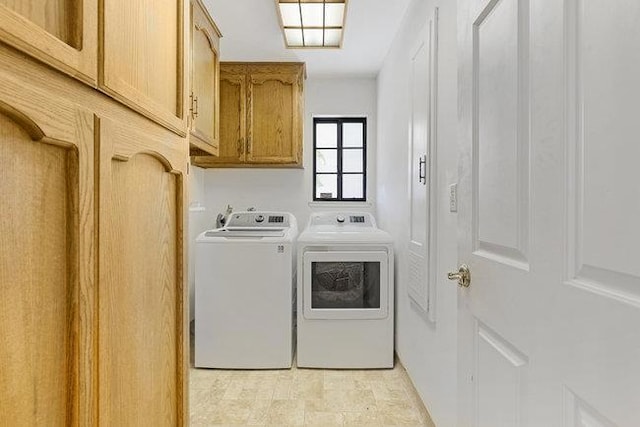 laundry room featuring washing machine and dryer and cabinets