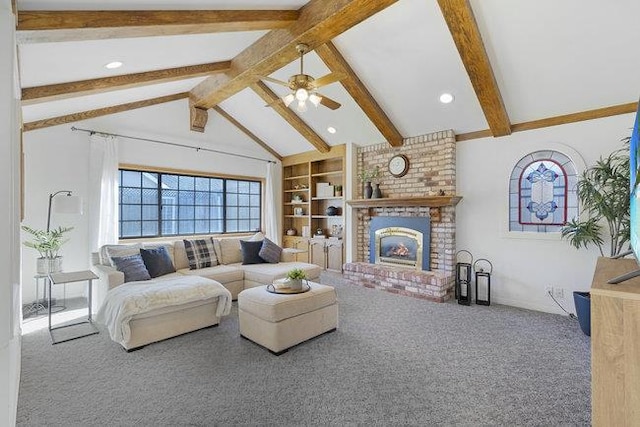 carpeted living room with ceiling fan, a brick fireplace, built in features, and vaulted ceiling with beams