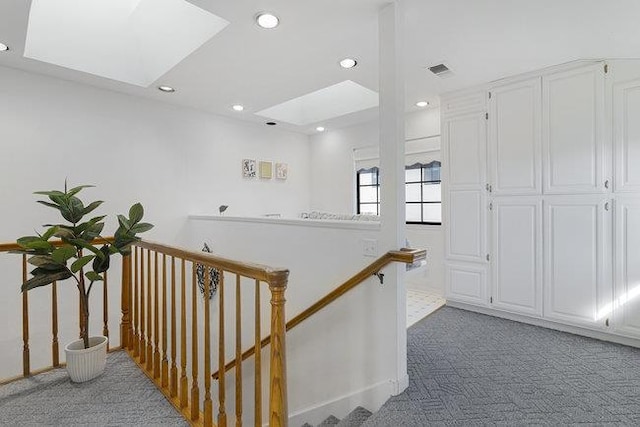 hallway with a skylight and carpet