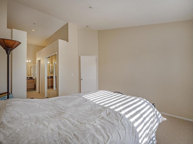 bedroom featuring ensuite bathroom and light carpet