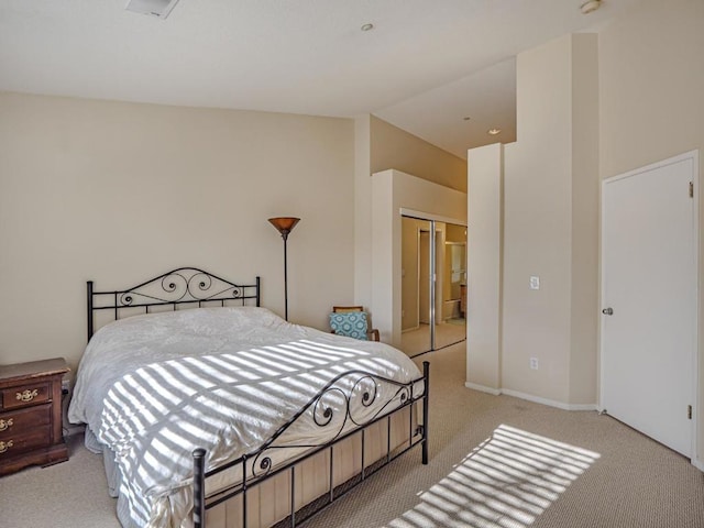 carpeted bedroom with a closet and lofted ceiling