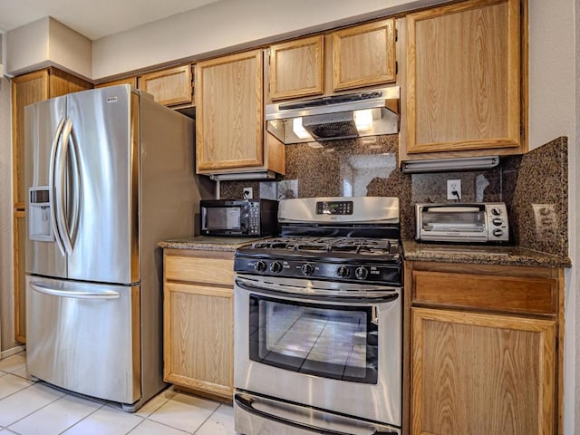 kitchen featuring decorative backsplash, light brown cabinets, light tile patterned floors, and stainless steel appliances