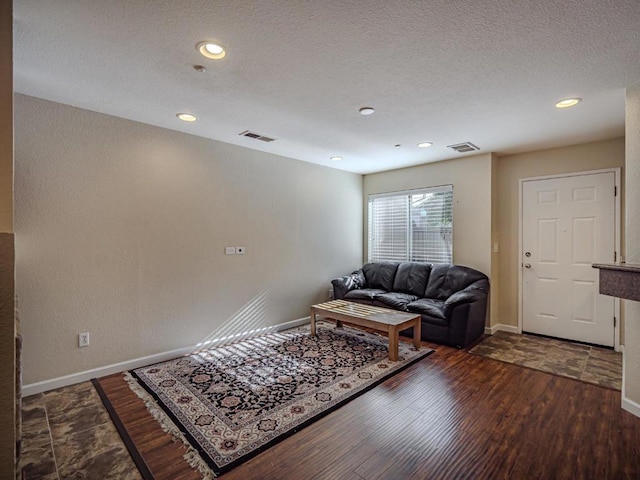 living room featuring dark hardwood / wood-style flooring and a textured ceiling