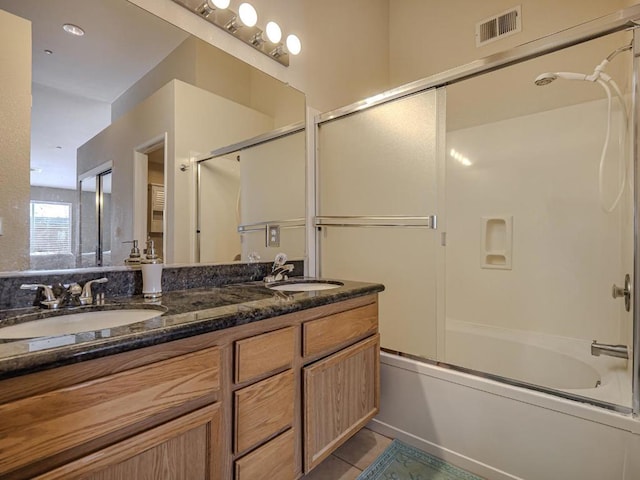 bathroom with tile patterned flooring, vanity, and shower / bath combination with glass door