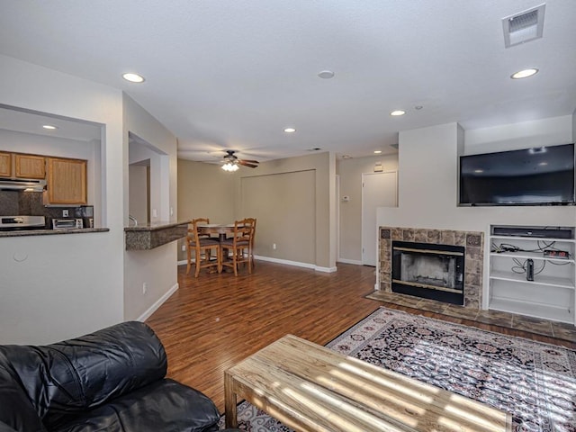 living room with a fireplace, hardwood / wood-style flooring, and ceiling fan