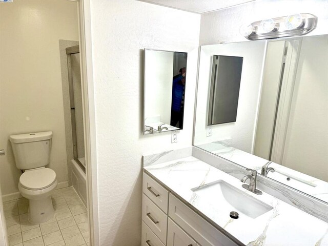 full bathroom with toilet, enclosed tub / shower combo, vanity, and tile patterned floors