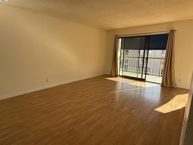 unfurnished room featuring dark hardwood / wood-style floors and a textured ceiling