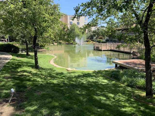 view of community with a water view and a yard