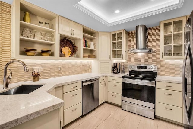 kitchen with sink, appliances with stainless steel finishes, wall chimney range hood, and cream cabinets