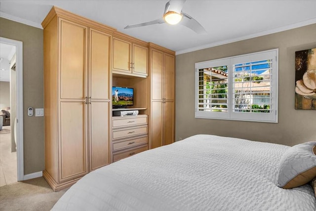 carpeted bedroom with ceiling fan and ornamental molding