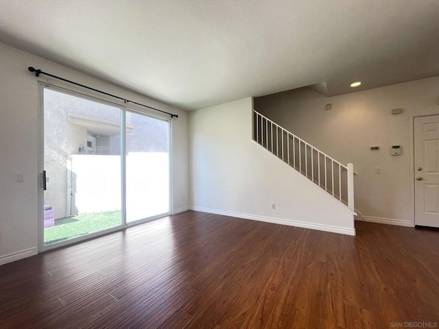 unfurnished living room with dark wood-type flooring