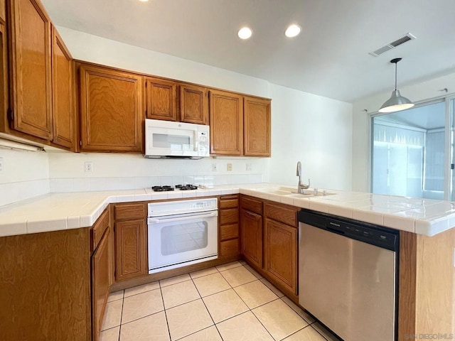 kitchen featuring decorative light fixtures, kitchen peninsula, tile counters, and white appliances