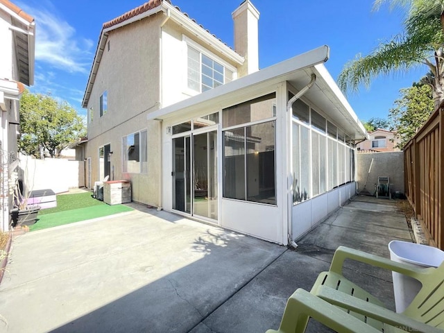 back of property with a patio area and a sunroom