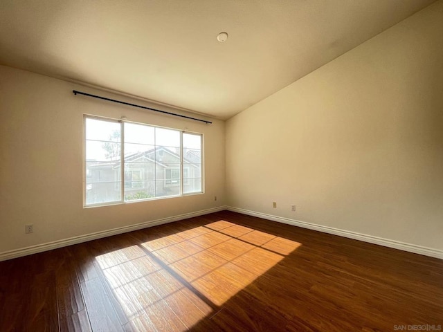 empty room featuring vaulted ceiling and hardwood / wood-style floors