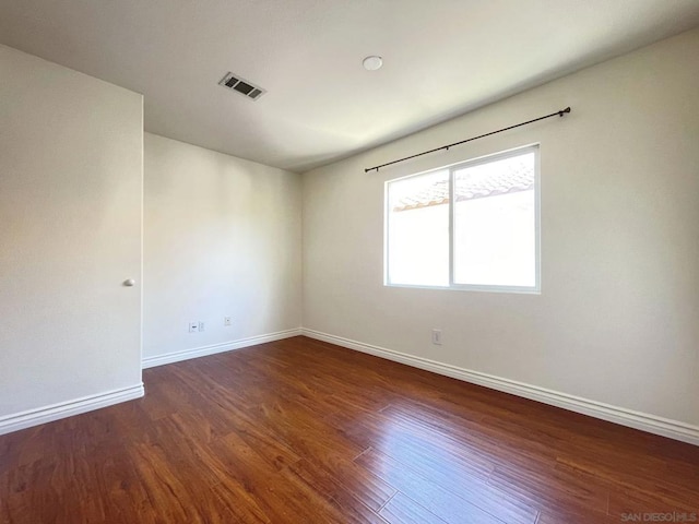 spare room with dark wood-type flooring