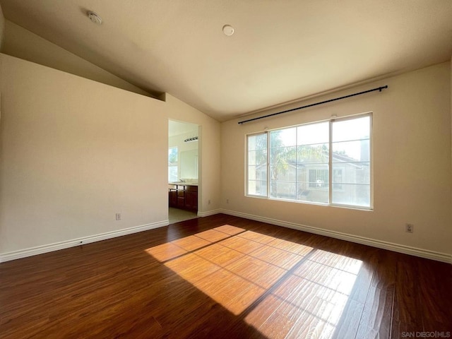 empty room featuring vaulted ceiling and hardwood / wood-style flooring