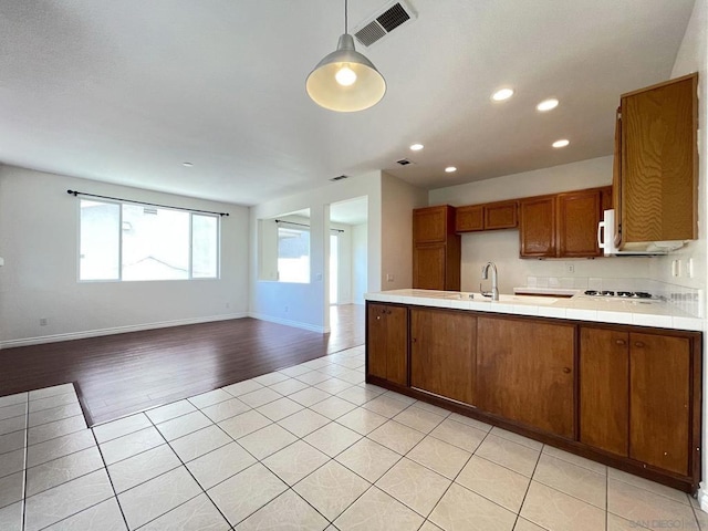 kitchen with tile countertops, pendant lighting, sink, white appliances, and light wood-type flooring