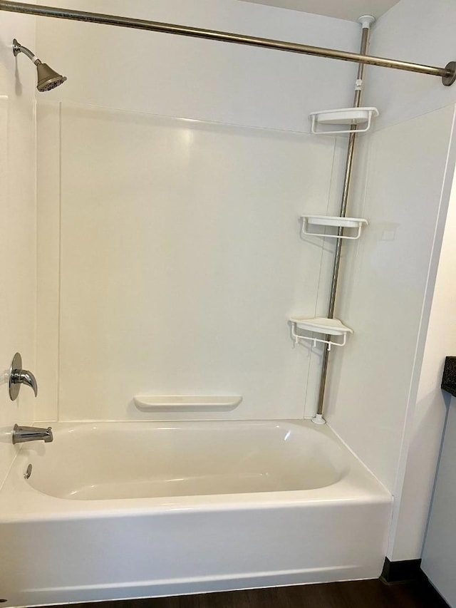 bathroom with shower / bath combination and hardwood / wood-style floors