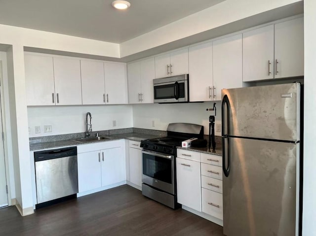 kitchen with sink, white cabinetry, appliances with stainless steel finishes, and dark hardwood / wood-style floors