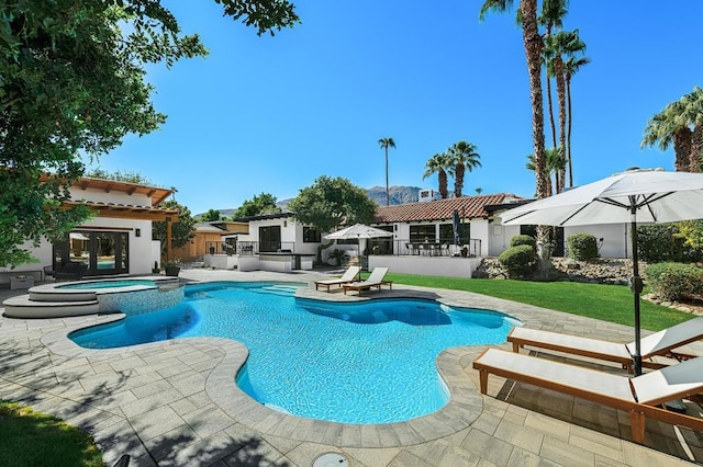 view of pool featuring a patio area, an outdoor kitchen, an in ground hot tub, and exterior bar