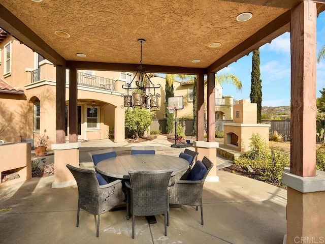 view of patio featuring exterior fireplace and a balcony