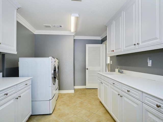 washroom with light tile patterned floors, separate washer and dryer, cabinets, ornamental molding, and sink