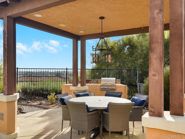 view of patio / terrace featuring a grill, an outdoor kitchen, and a water view